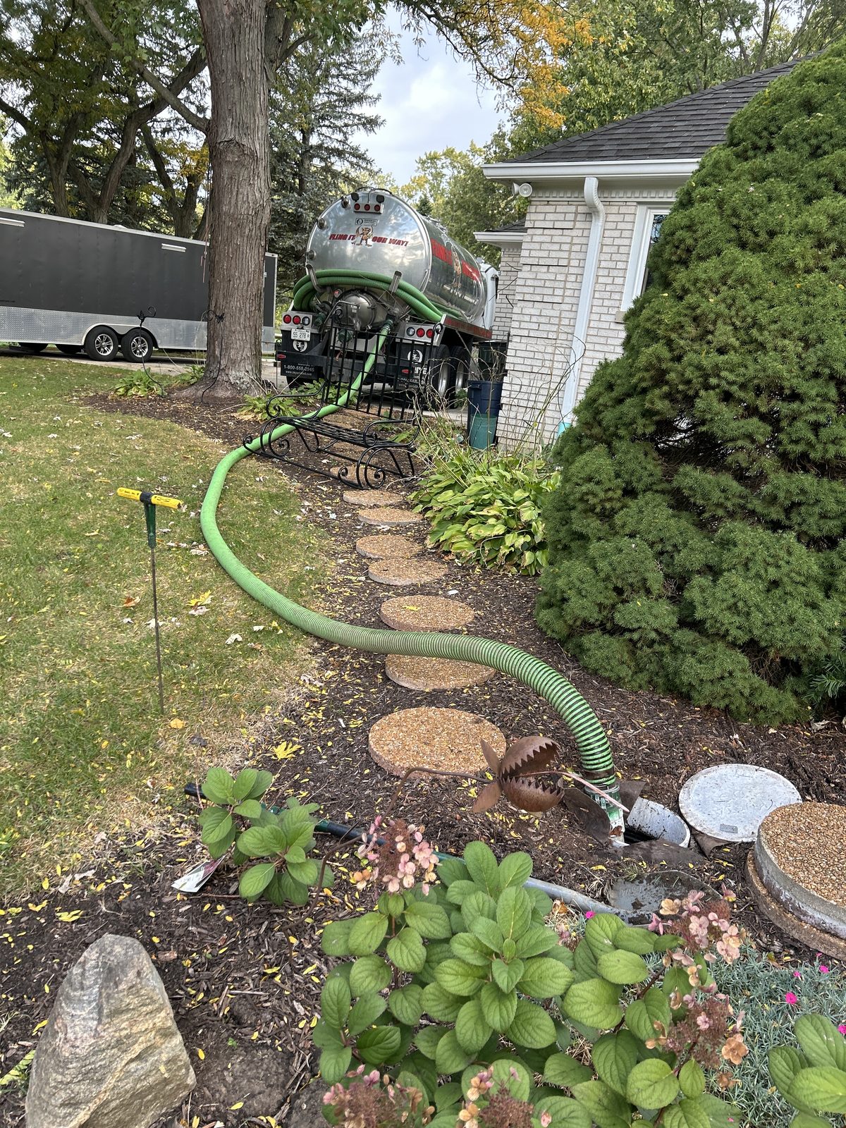 Vacuum hose run carefully along a stepping-stone path through landscaping